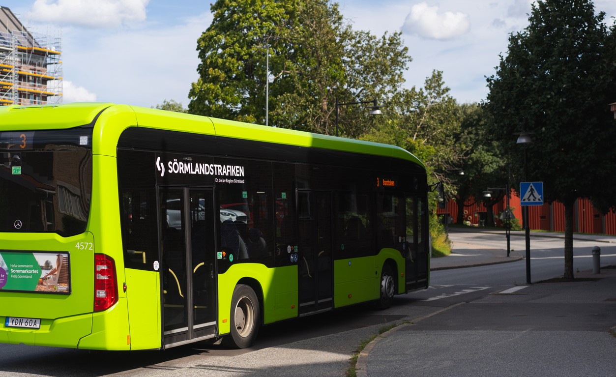 En av Sörmlandstrafikens gröna bussar som kör på en liten väg. 