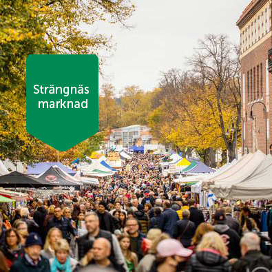 Bilden visar massor av folk som besöker marknaden. I bilden står också texten "Strängnäs marknad".
